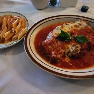 Chicken parmigiana with penne pasta in a pink sauce