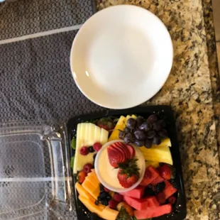 a plate of fruit and a bowl of berries