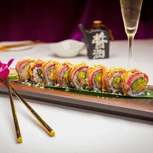 a sushi roll on a platter with chopsticks