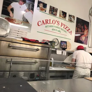 Carlo&apos;s sign and one of the brothers preparing another amazing pizza.