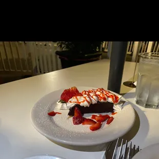 a plate of dessert with strawberries and ice cream