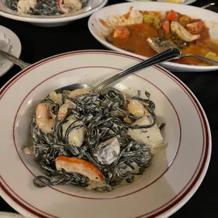 black pasta with seafood, split portion.