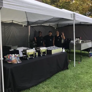 two men standing under a tent