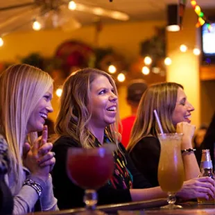 a group of women sitting at a bar