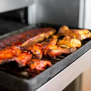 a pan of ribs cooking in the oven