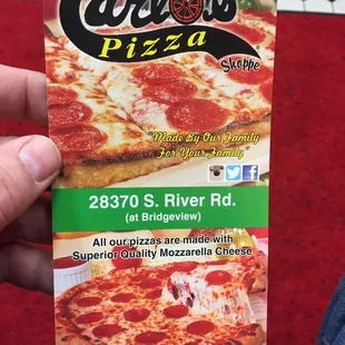a hand holding a pizza box
