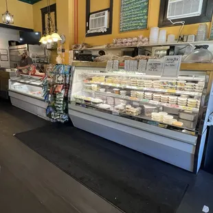 Inside the establishment, 2 of their cases, one with dessert, one with carryout deli fare