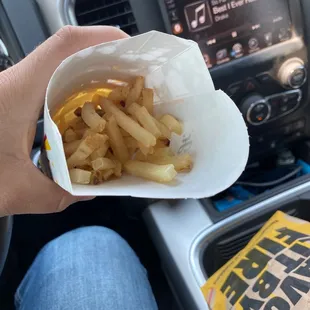 a person holding a bag of french fries