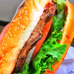 a hand holding a hamburger