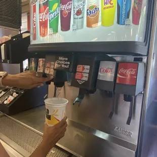 a woman filling a cup of soda into a machine