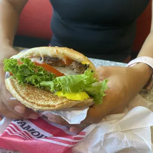 a person holding a hamburger