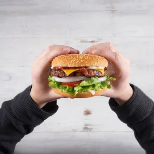 a person holding a hamburger