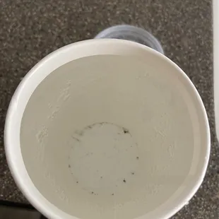 Soda in a cup with nasty black particles.