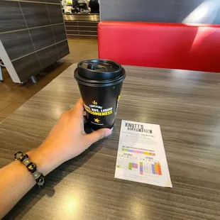 a hand holding a cup of coffee
