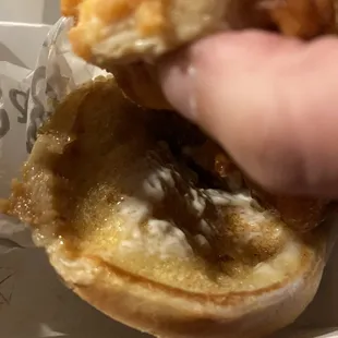 a hand holding a half eaten sandwich