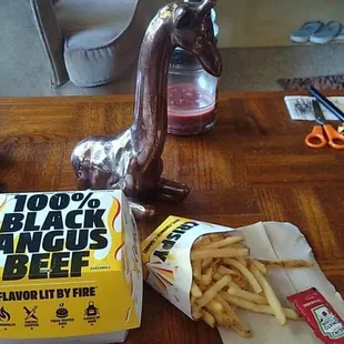 a table with fries, a hot dog and a bottle of black angus beef