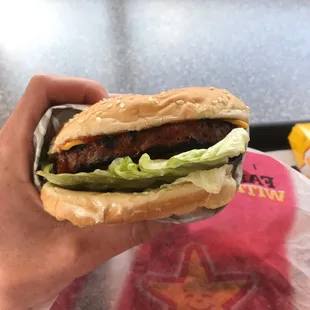 a hand holding a hamburger