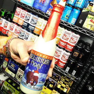 a hand holding a bottle of beer