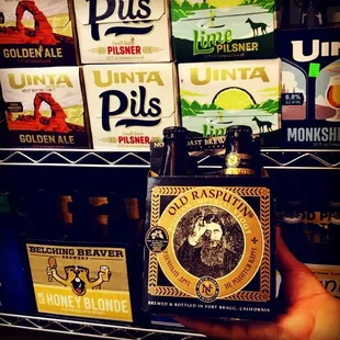 a hand holding a bottle of beer