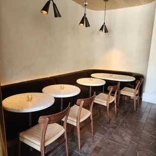 a corner of a restaurant with tables and chairs