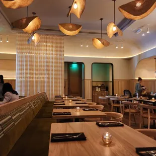 the interior of a restaurant with wooden tables and chairs