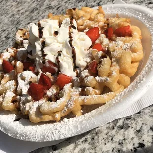 Customers funnel cake! Classic funnel cake with powder sugar, fresh strawberries, chocolate syrup and whipped cream