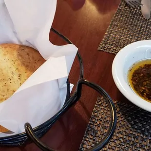 a basket of bread and a bowl of olive oil
