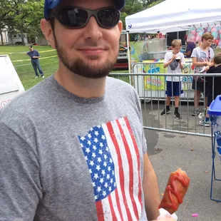Husband enjoying a corn dog.