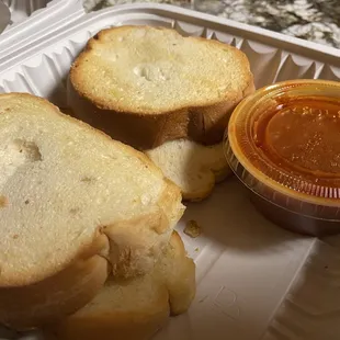 a sandwich and dipping sauce in a styrofoam container