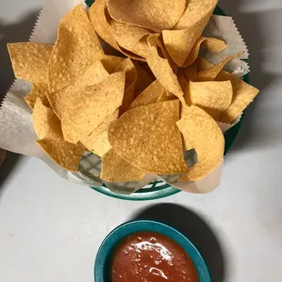 a bowl of tortillas and a bowl of salsa
