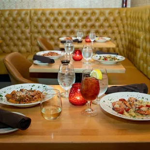 a table with plates of food and glasses of wine