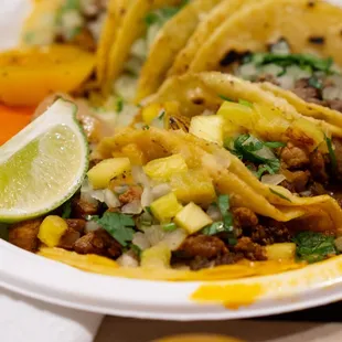 a plate of tacos with a lime wedge