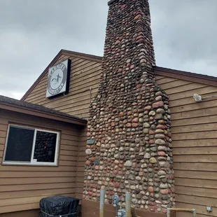 a brick chimney with a clock on it