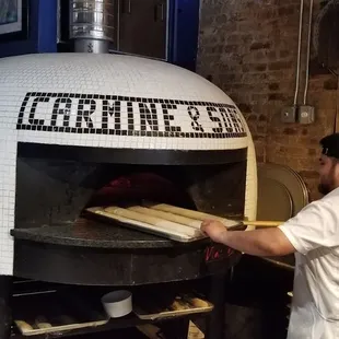 a man putting bread into an oven