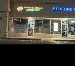 a photo of a storefront at night