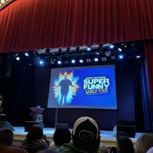 a stage with a man on a screen