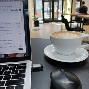 a cup of coffee next to a laptop