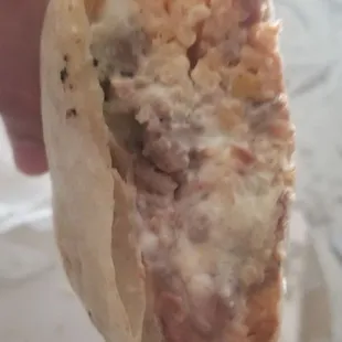a hand holding a burrito