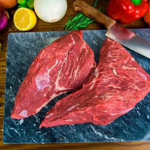 two pieces of meat on a cutting board