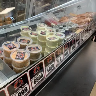 a variety of cheeses in a display case