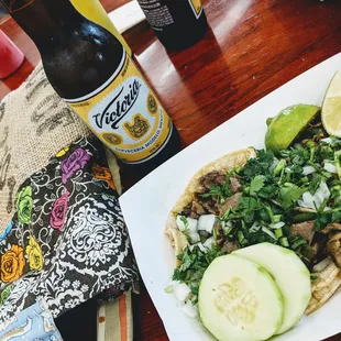One taco de lengua and a taco de lomo encebollado