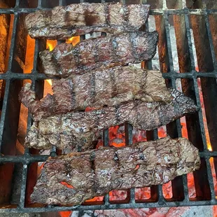 steaks cooking on a grill