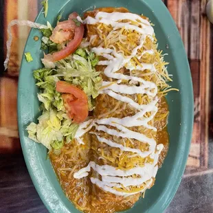 Carne asada burrito with beans, rice and cheese w/ green chili verde sauce on top.