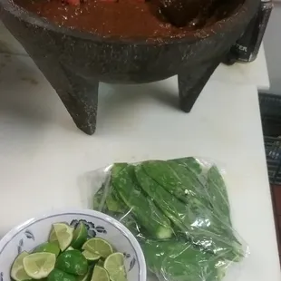 a bowl of chili and limes