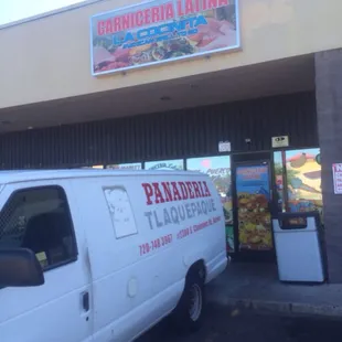 a white van parked in front of a restaurant