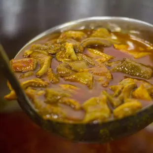 a spoon full of chili and peppers