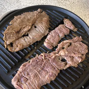 steaks cooking on a grill