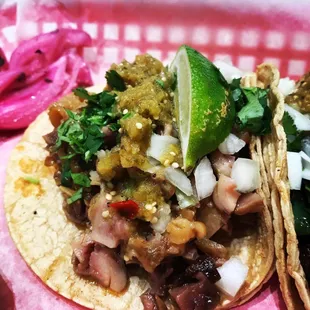 two tacos on a pink plate