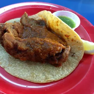 Chunks of Chicharrón Guisado in spicy salsa roja. Handmade tortillas. They usually chop it up, but this time they just let it rock:/