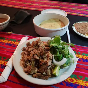 Dinner for one. Carnitas plate with tortilla, rice and beans.